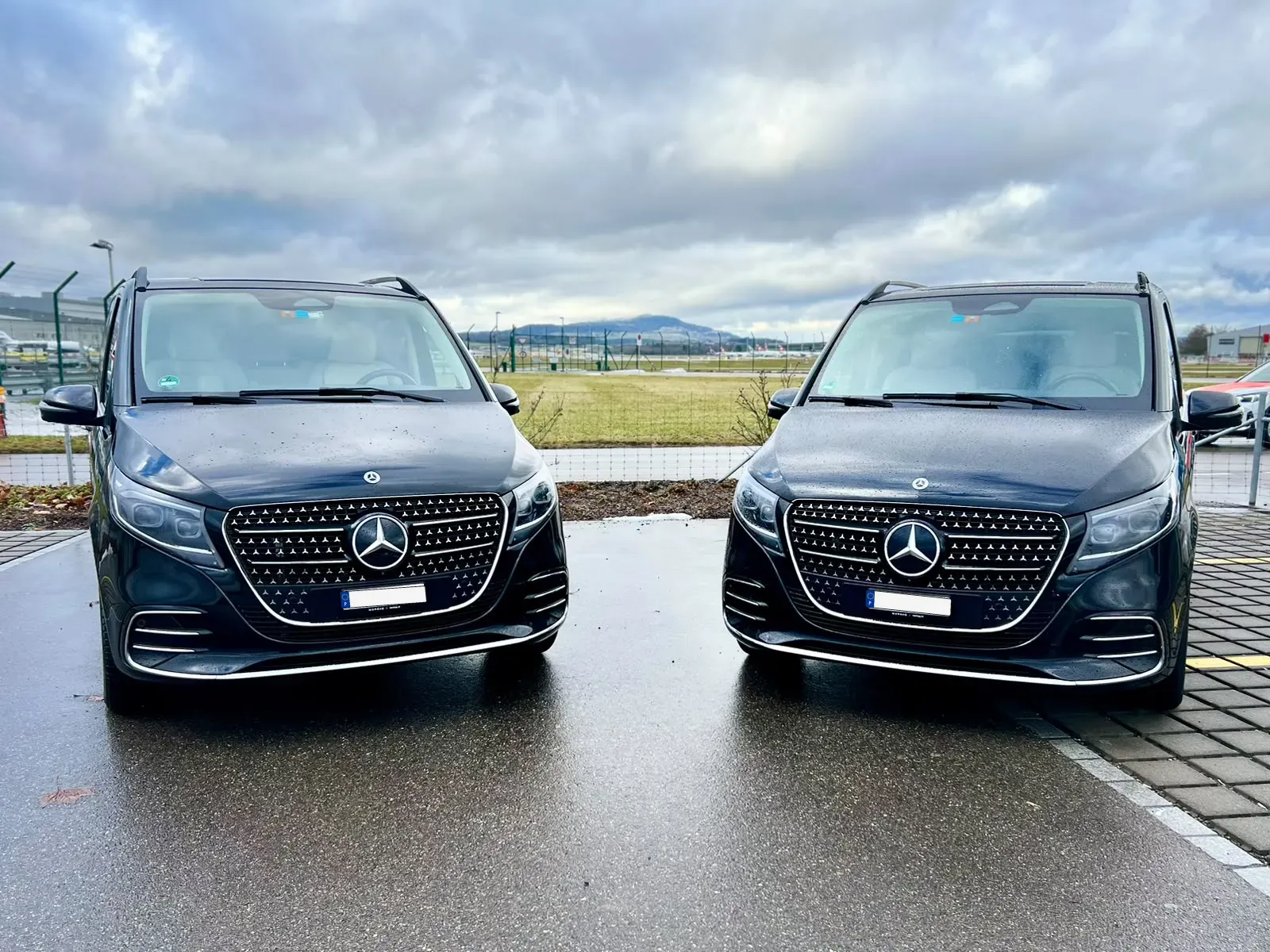 Zwei schwarze Mercedes-V-Klasse-Vans nebeneinander
