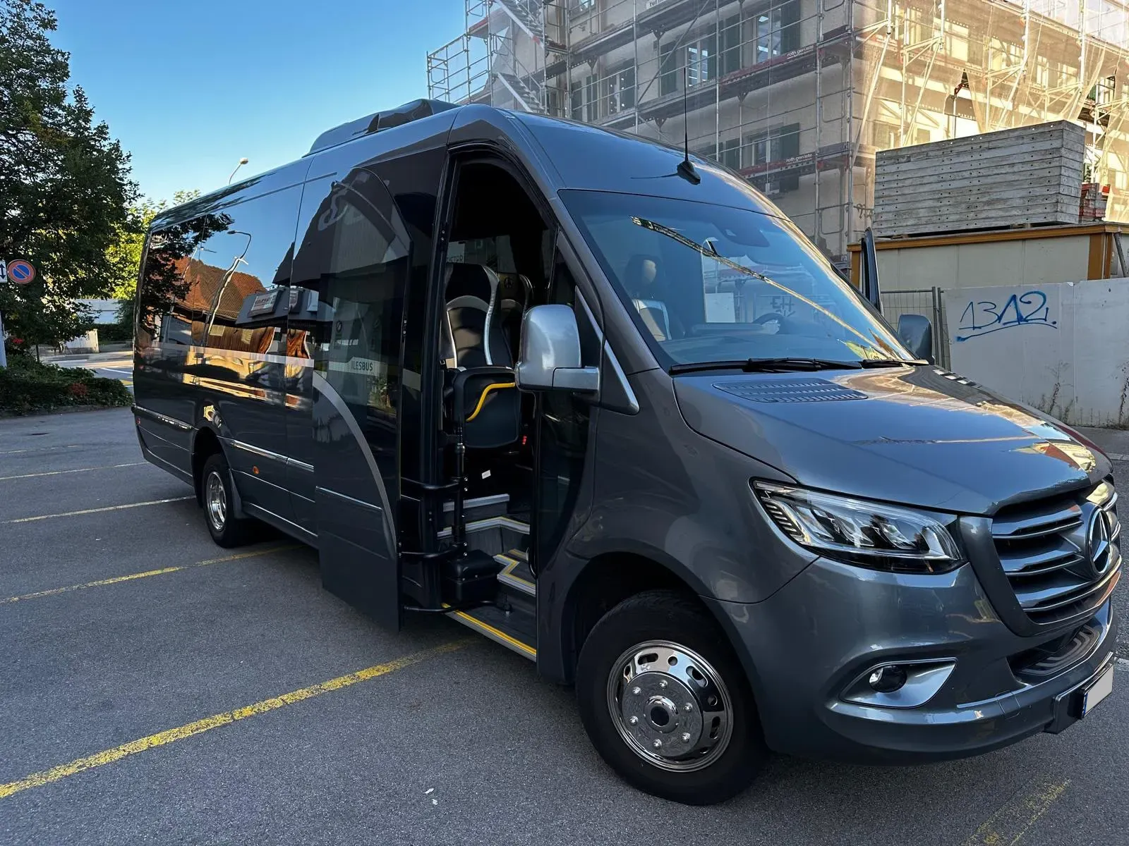 Grauer Kleinbus Mercedes Sprinter mit offener Passagiertür
