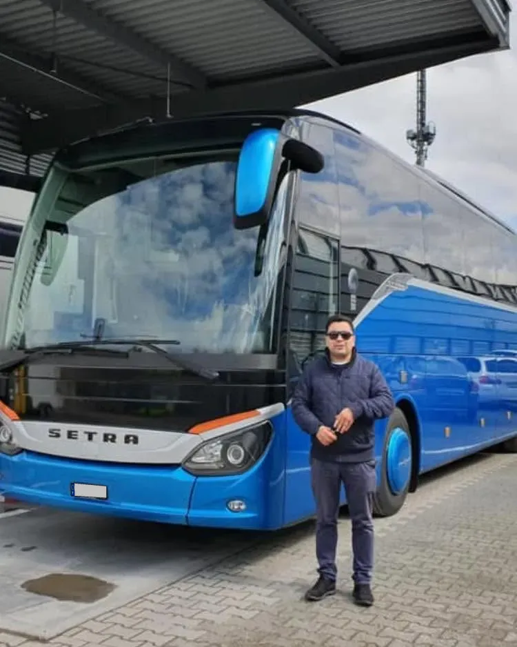 Chauffeur von Leonardo Travel neben einem blauen Setra-Car